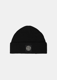 Packshot de face d'un bonnet en laine côtelée noir Stone Island orné du patch logo boussole au centre du revers.