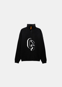 Packshot à plat de face du pull Gertrude noir à col demi-zip, motif logo CG en intarsia blanc et tirette orange