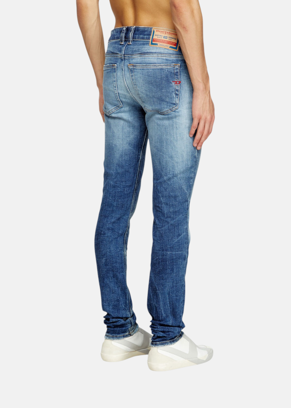 Jeans Diesel 1979 Sleenker skinny bleu foncé portés par un homme, vue de côté et de dos. Montre l'ajustement du skinny et l'étiquette Diesel à la taille.