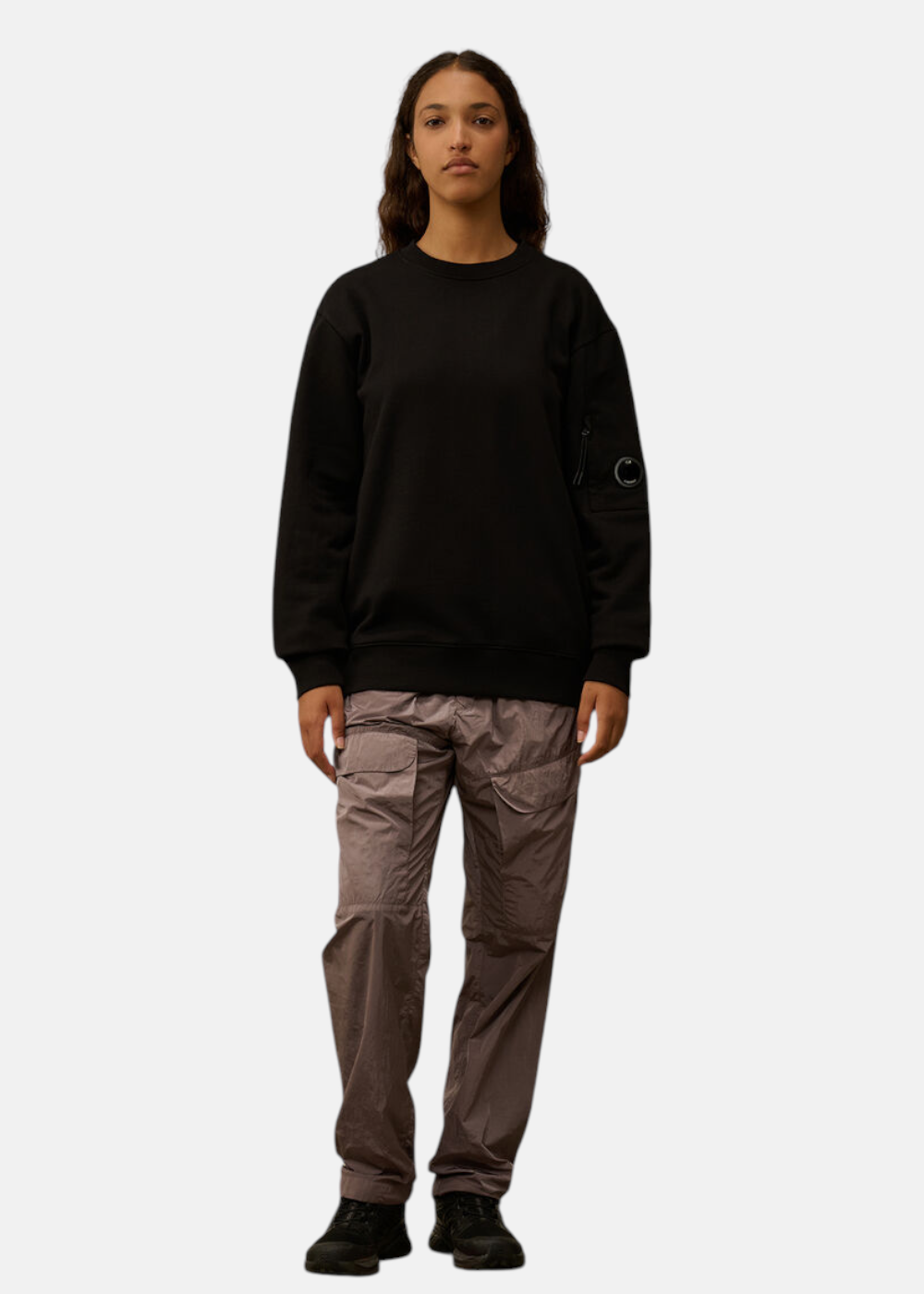 Look complet femme, sweat C.P. Company col rond noir avec un pantalon cargo.
