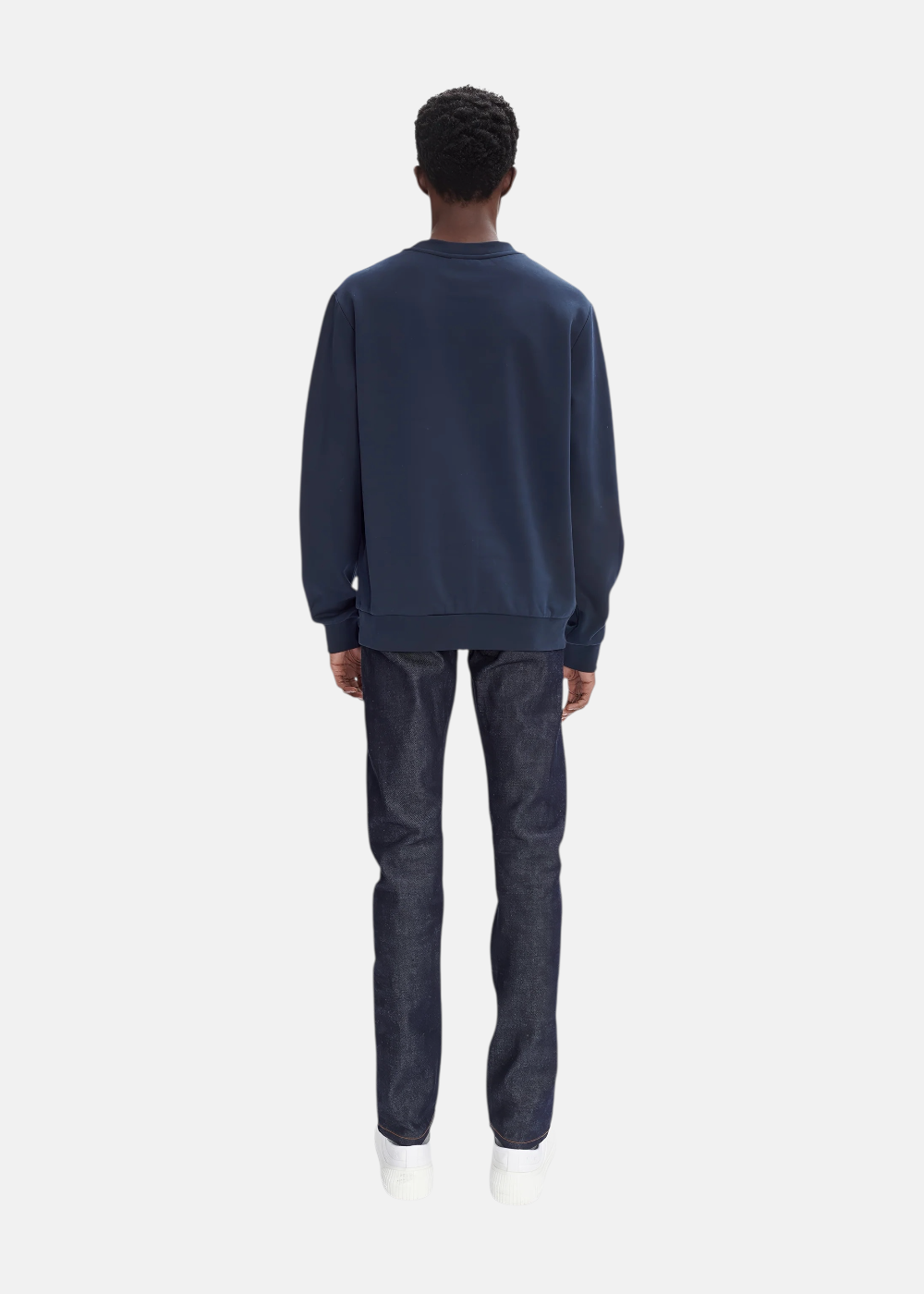 Deuxième vue du look de dos  homme avec sweat A.P.C. marine, jean brut bleu et baskets blanches.