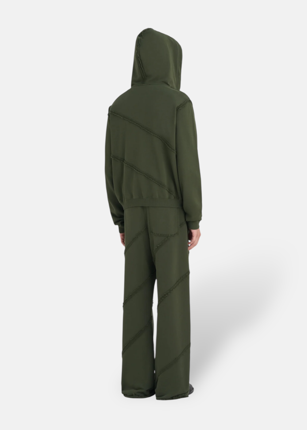 oufit de dos avec un mannequin portant le Sweat à capuche Zippé Études Studio vert forêt avec son pantalon assortie. cette photo mets en avant la coupe droite de ce sweat études