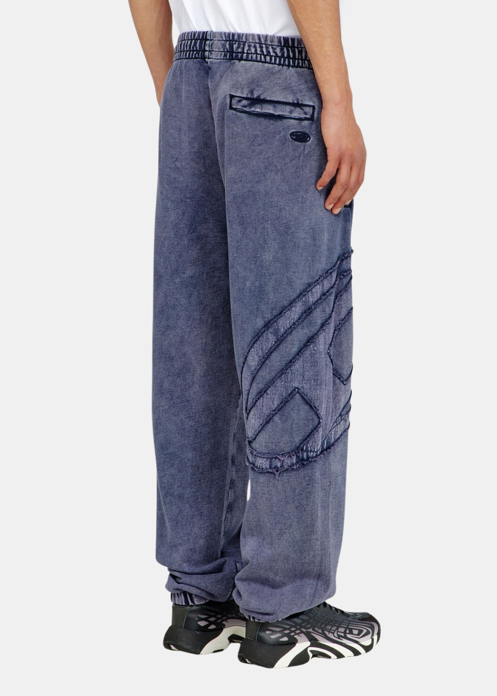Vue de dos et de profil du pantalon de survêtement délavé bleu porté avec détail du logo appliqué