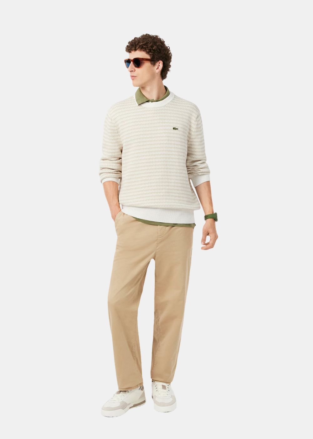 Tenue complète avec le pull Lacoste beige en maille fantaisie associé à un pantalon chino beige.