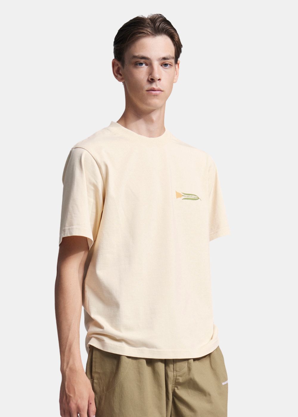 Homme portant le t-shirt beige Bram's Fruit, logo fleur horizontal au niveau du cœur.