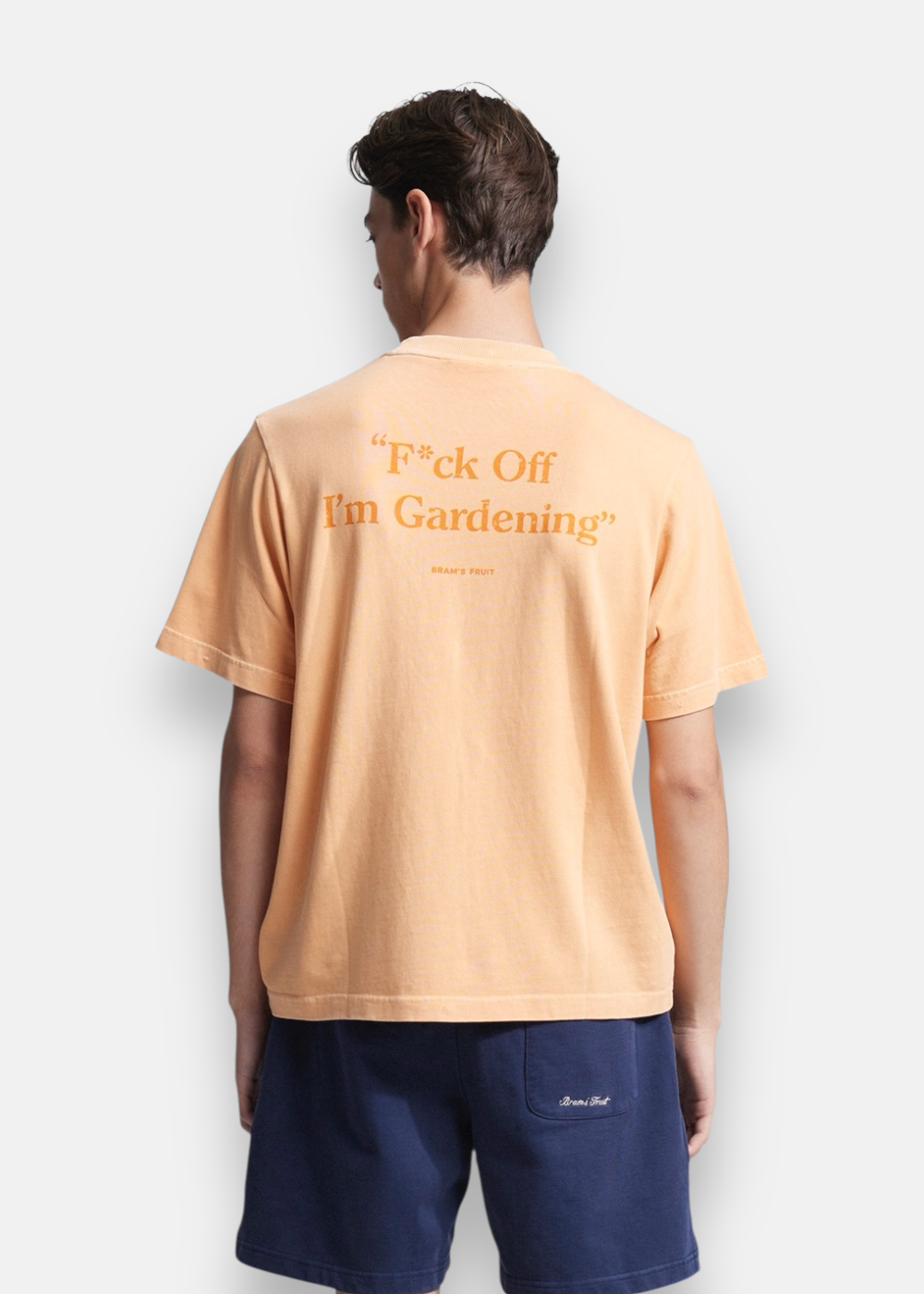 Vue de dos d'un homme portant le t-shirt orange avec le message F*ck Off I'm Gardening imprimé en orange.